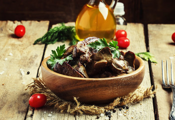 Wall Mural - Braised turkey liver in a bowl on the old wooden background, sel