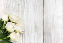 White Roses On A Wooden Table