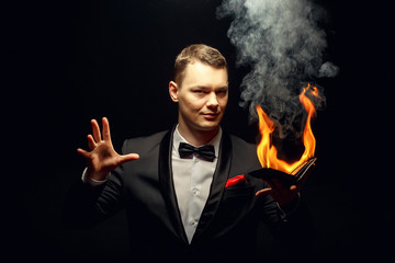 Young brunette magician in costume performing flame tricks