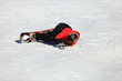 © Stanisław Błachowicz - Dorosły mężczyzna leży na śniegu z deską snowboardową.
