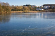 © Martin Henke - Winterlandschaft: Zugefrorener See mit Reflektionen und Textfreiraum vor moderner Architektur