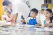© Blue Jean Images - Little children painting in art class with teacher