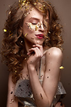 Beautiful Girl In An Evening Dress And Gold Curls. Model In New Year's Image With Glitter And Tinsel. Holiday Picture. Christmas Atmosphere.