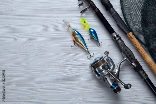Fotografía Fishing tackle - fishing spinning, hooks and lures on wooden bac