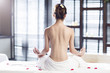 © Blue Jean Images - Rear view of a shirtless woman meditating on massage table
