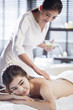 © Blue Jean Images - Young woman receiving back massage from masseuse in spa