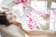 © Blue Jean Images - Beautiful young woman relaxing in bathtub with rose petals