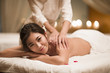 © Blue Jean Images - Masseuse giving a back massage to a woman in a spa