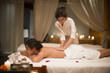 © Blue Jean Images - Masseuse giving a back massage to a woman in a spa