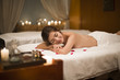 © Blue Jean Images - Smiling woman relaxing on massage table in spa