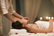 © Blue Jean Images - Masseuse giving a facial massage to a woman in a spa