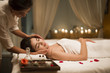 © Blue Jean Images - Young woman receiving facial massage from masseuse in spa