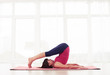 © ArtFamily - Sporty fit mature yogini practices yoga halasana or plow pose