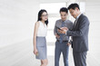 © Blue Jean Images - Business people using smartphone in office