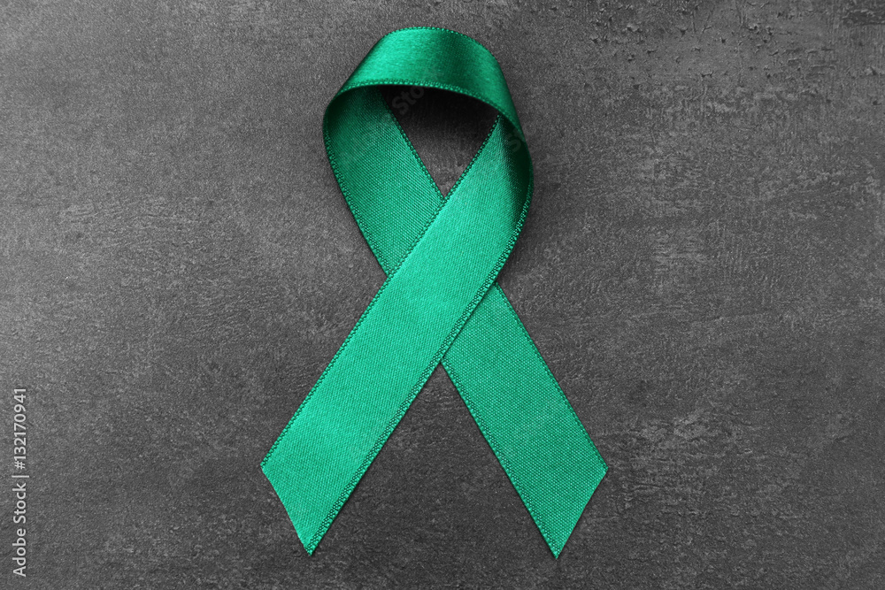 Green ribbon on dark background. Mitochondrial diseases and kidney cancer concept