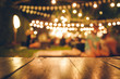 © escapejaja - Image of wooden table in front of abstract blurred restaurant lights background