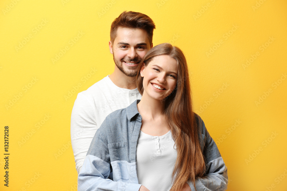 Cute young couple on color background