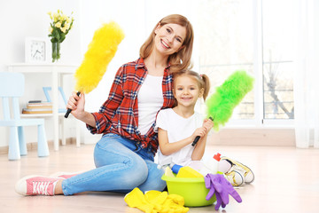 Wall Mural - Little girl and her mother with cleaning supplies at home