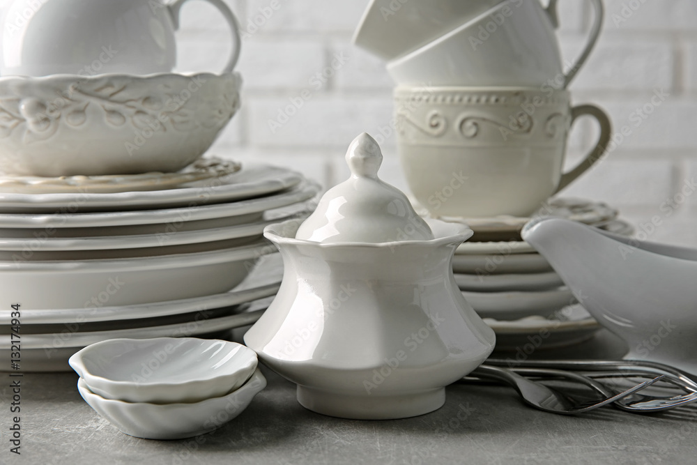 Porcelain dishware on table and white brick wall background