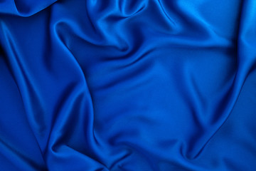 Close up wave blue silk or satin fabric background