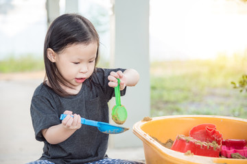 Wall Mural - Little asian girl playing in sandbox