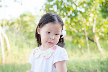 Wall Mural - .Little asian girl with flower on hair in garden