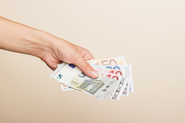 Woman's hand with money on a light background