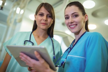 Poster - Portrait of two female surgeon using digital tablet