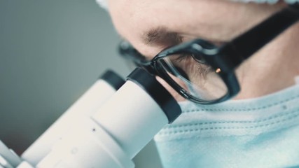 Wall Mural - middle age female scientist in uniform and medical face mask doing microscopic examination in labora