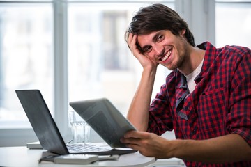 Aufkleber - Graphic designer using laptop and digital tablet at his desk