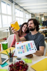 Aufkleber - Graphic designers discussing over a container at their desk
