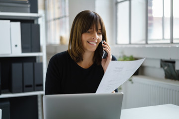 Canvas Print - mitarbeiterin im büro mit unterlagen und telefon