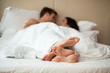 © DenisProduction.com - Couple's feet in bed. Man with woman under blanket. Rest in home comfort.