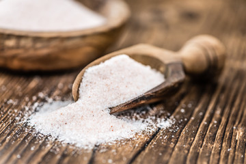 Portion of Himalayan Salt on wooden background (selective focus)