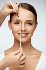 Wall Mural - beautiful woman with makeup and make-up brow brush