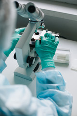 Wall Mural - close up crop view of scientist hands putting microscope glasses in special store box.