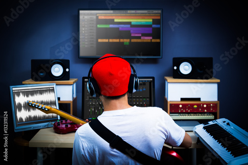 Fotografía back of male musician playing guitar in recording studio for music background
