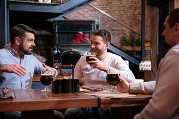 Cheerful happy men meeting in the pub