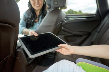 Poster - woman giving tablet pc to her child in car