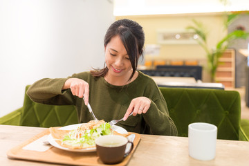 Woman having pancake in restaurant