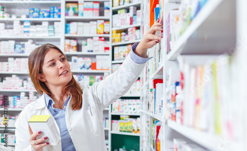 Fotografía Photo of a professional pharmacist checking stock in an aisle of a local drugstore