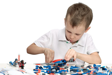 Young boy playing absorbedly with construction kit. With place for a text.