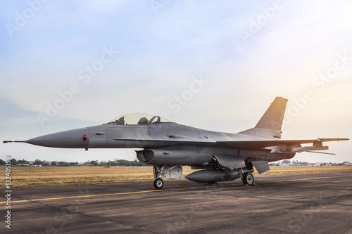 Plakat F16 sokół myśliwca samolot wojskowy zaparkowany na pasie startowym na zachód słońca