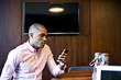 © Andy Paul - Black Businessman using a mobile phone in an office