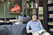 © Andy Paul - Informal black businessman with a mobile device in an office break out area