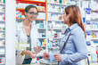 © Karanov images - Pharmacist talking with a customer at the pharmacy desk
