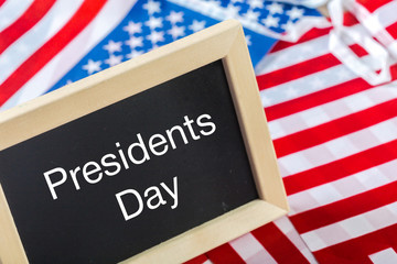 the text happy presidents day written in a chalkboard and a flag of the United States