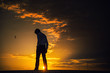 Silhouette of a man standing with a sad look on after sunset.