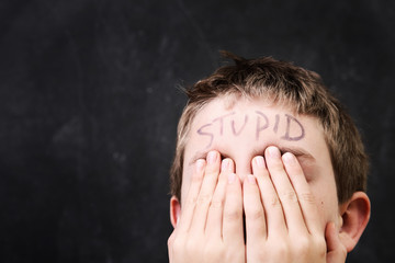 Wall Mural - Boy with stupid written on his forehead