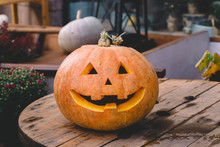 The Smiling Halloween Pumpkin Is On A Wooden Surface